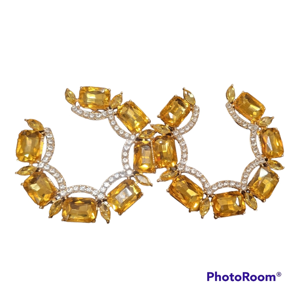 Gold earrings. Square shapes with clear jewels in the middle
